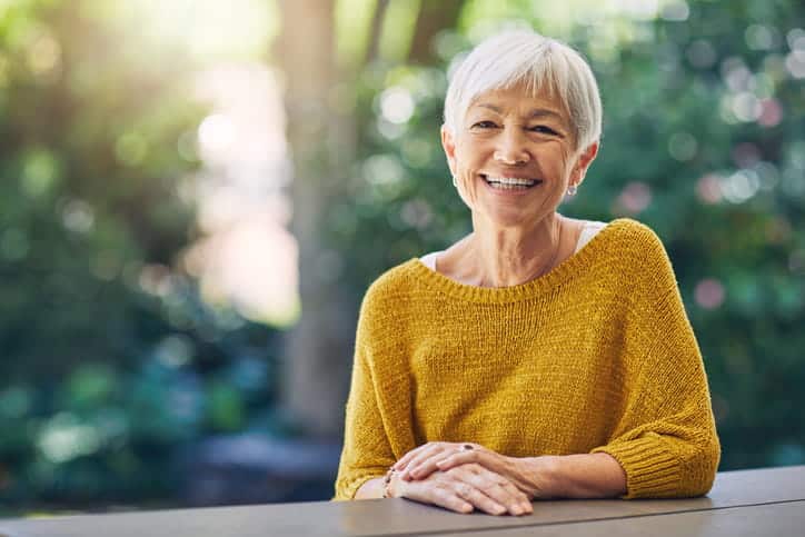 An Older Woman Smiling For The Camera. 