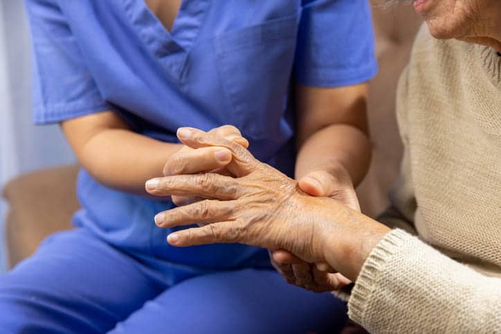 A Nurse Helping A Patient With Chronic Pain In Their Hands During Winter.