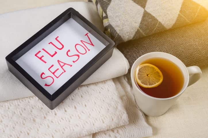 A Cup Of Tea Next To A Sign That Reads &Quot;Flu Season.&Quot;