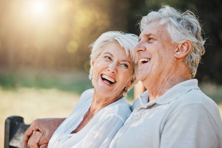 Two Seniors Smiling Together And Laughing. 