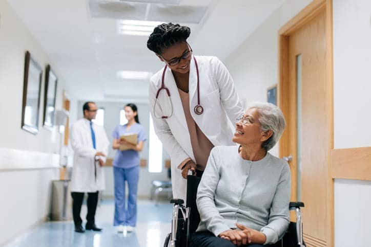 What Qualifies A Patient For Skilled Nursing Care? 1 A Nurse Assisting A Patient In A Wheelchair At A Skilled Nursing Facility.