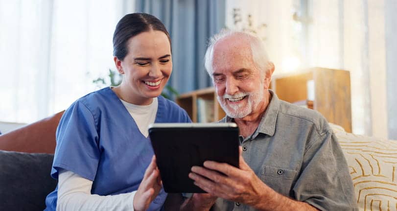A Nursing Aid Reviews Assisted Living Costs With One Of The Senior Residents.
