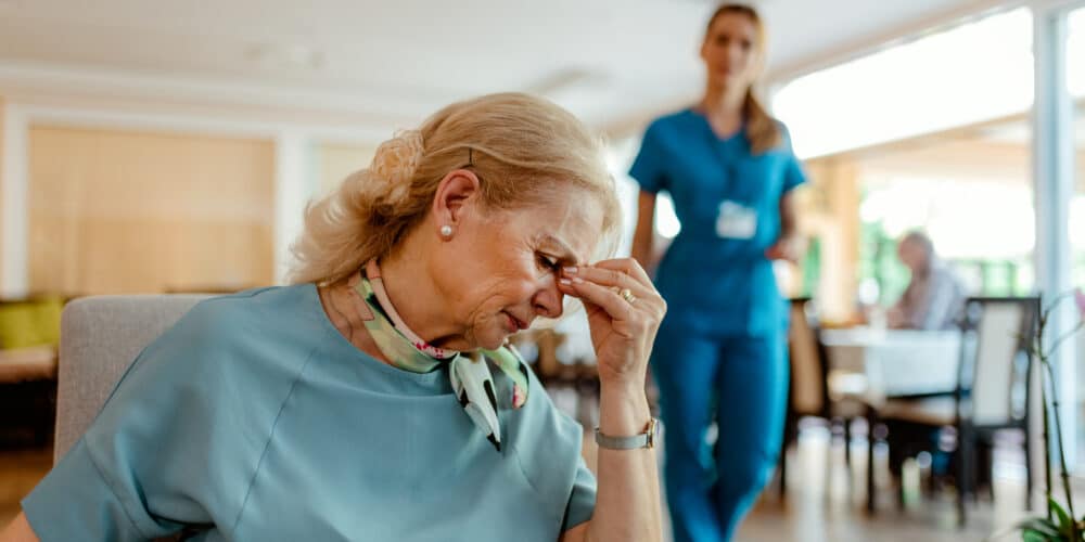 A Nursing Aid Coming To Assist An Elderly Patient With Alzheimer’s.