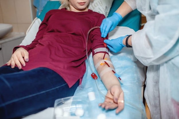 A Patient Is Hooked Up To A Dialysis Machine By A Nurse.