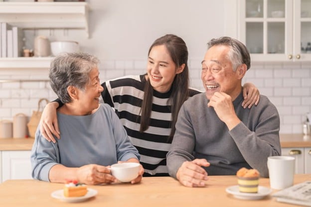 A Woman Smiles With Her Elderly Parents.