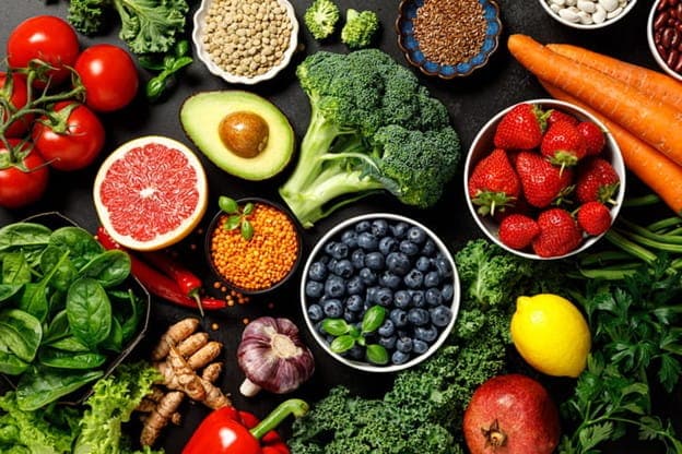 A Photo Of A Group Of Superfoods, Including Broccoli, Strawberries, Blueberries, Carrots, Nuts, And More.