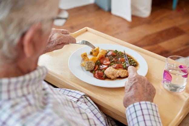 An Elderly Man Eats His Dinner.
