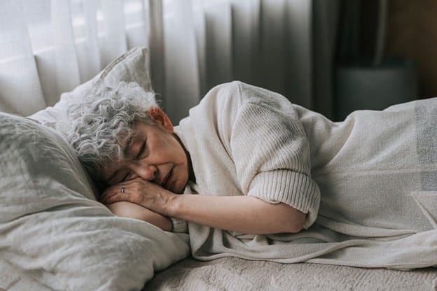 An Elderly Woman Sleeping In Her Bed.