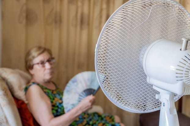 A Senior With Two Fans On Her Due To The Extreme Heat.