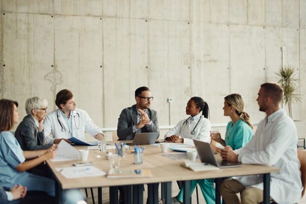 A Group Of Doctors Having A Meeting About A Patient'S Care.